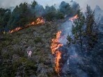 A wildfire burns on the slopes of the mountains. A wildfire burns on the slopes of the mountains.