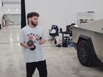 Adin Ross throws a dumbbell at his Tesla Cybertruck