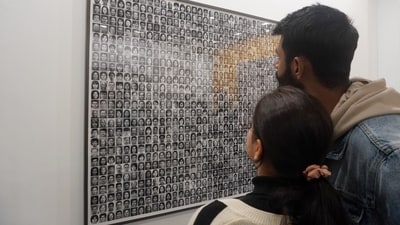Visitors look at ‘People Who Do Not Exist’ by Madhuban Mitra & Manas Bhattacharya at the PHOTOINK booth. Part of a new cycle of works made using AI, the typology comprises 1000 frontal headshots of all races and ethnicities, that both resemble and subvert generic ID photos used in official documents. ( Paroma Mukherjee/ Hindustan Times) Visitors look at ‘People Who Do Not Exist’ by Madhuban Mitra & Manas Bhattacharya at the PHOTOINK booth. Part of a new cycle of works made using AI, the typology comprises 1000 frontal headshots of all races and ethnicities, that both resemble and subvert generic ID photos used in official documents. ( Paroma Mukherjee/ Hindustan Times)