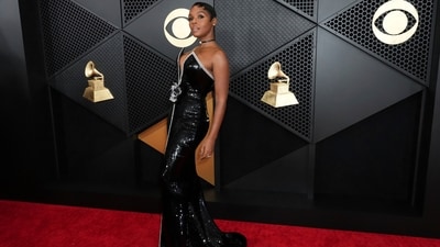 Janelle Monae wore a silver and black sequined Armani Privè dress with rosette detailing at the waist to the Grammy Awards 2024. She completed the look with a black choker featuring a diamond centrepiece, a sleek hairdo, and striking glam picks.&nbsp; (Jordan Strauss/Invision/AP)