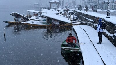 A boatman can be seen crossing Dal Lake during snowfall in Srinagar on Sunday. (HT Photo/Waseem Andrabi) A boatman can be seen crossing Dal Lake during snowfall in Srinagar on Sunday. (HT Photo/Waseem Andrabi)