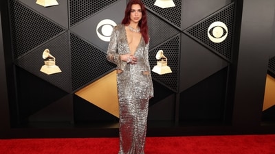 Dua Lipa stuns on the Grammy Awards red carpet in a metallic gown. She wore a custom Courrèges and a Tiffany necklace. Her outfit featured a plunging v-neckline, full sleeves, a maxi hem and side cut-outs for a chic look. She finished off her look with nude lips, rouged cheeks and softly curled red hair. (REUTERS/Mario Anzuoni)