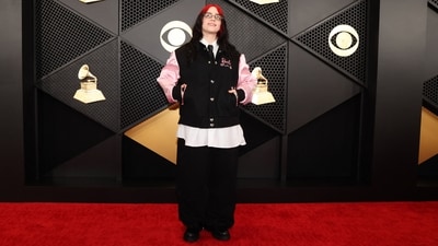 Billie Eilish, the Brabie songwriter, looked effortlessly stylish on the red carpet in a black and pink Barbie bomber jacket. She redefined red carpet glamour with an oversized white shirt, black tie and baggy black trousers. With a pair of sheer glasses, minimal make-up and her red dyed hair left open at the centre part, she finished off her look. (REUTERS/Mario Anzuoni)