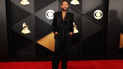 John Legend stole the show at the Grammys in a dapper black tuxedo with silken blouse. While the blazer features padded sleeves, an open front, and notch lapels, the pants have a high-rise waistline and a baggy fitting. Meanwhile, the knot detail on the shirt added the edgy twist to the outfit.&nbsp; (REUTERS)