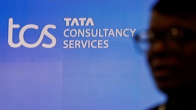 A man walks past a logo of Tata Consultancy Services (TCS) before a press conference. (Reuters)