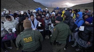 US Border Patrol agents speak with migrants seeking asylum, mainly from Colombia, China and Ecuador, in a makeshift, mountainous campsite after crossing the border between Mexico and the United States, on Friday. (AP) US Border Patrol agents speak with migrants seeking asylum, mainly from Colombia, China and Ecuador, in a makeshift, mountainous campsite after crossing the border between Mexico and the United States, on Friday. (AP)