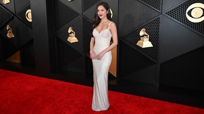 Olivia Rodrigo, who received six Grammy nominations, wore a sleek cream-coloured vintage Versace dress with sequins and bold red lipstick on the red carpet.&nbsp; (AFP)