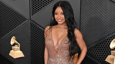 Halle Bailey dazzled on the Grammys red carpet in a beige bodycon gown embellished with shimmerig sequins and featuring a deep neckline. She wore the dress with a diamond necklace, centre-parted locks, and minimal glam.&nbsp; (AFP)