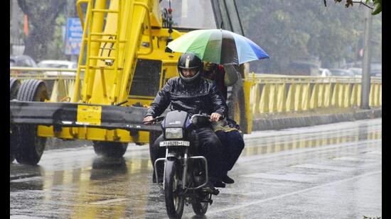Commuters making their way through rain in Amritsar that recorded a low of 4.2 degrees Celsius on Monday. (Sa,eer Sehgal/HT)