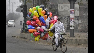 A balloon seller on bicycle out on a cold winter morning in Amritsar on Tuesday. (Sameer Sehgal/HT)