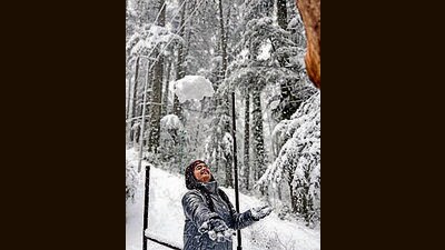 A tourist enjoys during snowfall at Patnitop in Udhampur on Tuesday. (ANI)