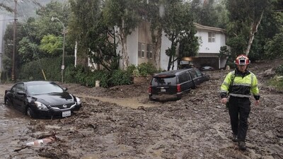 A firefighter walks on mud and rocks from a mudslide during a storm in Los Angeles, California,. (Bloomberg) A firefighter walks on mud and rocks from a mudslide during a storm in Los Angeles, California,. (Bloomberg)