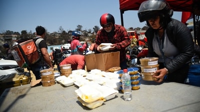 Delivery app workers distribute lunches and water donated by the companies to firefighters in Villa Independencia, Valparaiso region in Chile on February 5. (AFP) Delivery app workers distribute lunches and water donated by the companies to firefighters in Villa Independencia, Valparaiso region in Chile on February 5. (AFP)