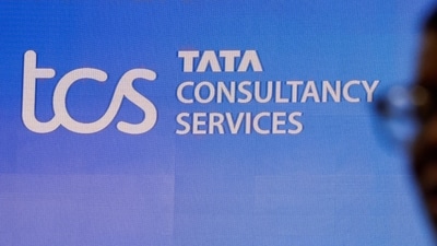 TCS Share price today: A man walks past a logo of Tata Consultancy Services (TCS) before a press conference. (Reuters)