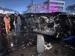 People inspect a vehicle, after what security sources said was a deadly drone strike, in Baghdad, Iraq,