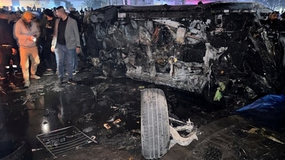 People inspect a vehicle, after what security sources said was a deadly drone strike, in Baghdad, Iraq, (REUTERS)
