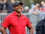 FILE PHOTO: Tiger Woods smiles before he plays his shot from the first tee during the PNC Championship at The Ritz-Carlton Golf Club.