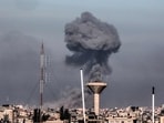 This picture taken from Rafah, in the southern Gaza Strip, shows smoke rising over buildings in Khan Yunis during Israeli bombardment on February 8, 2024,