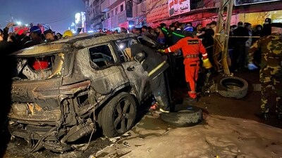 Civil defense members gather at the site of a burned vehicle targeted by a U.S. drone strike in east Baghdad, Iraq. (AP)