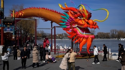 A couple takes a selfie with a giant dragon lantern decorated near the frozen Houhai Lake in Beijing, Thursday, Feb. 8, 2024. Chinese will celebrate Lunar New Year on Feb. 10 this year which marks the Year of the dragon on the Chinese zodiac. (AP Photo/Andy Wong) (AP)