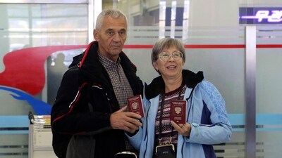 Tourists show their passports as a group of Russian tourists, likely the first foreign travelers from any country to enter North Korea since the pandemic arrive at the Pyongyang International Airport in Pyongyang. (AP) Tourists show their passports as a group of Russian tourists, likely the first foreign travelers from any country to enter North Korea since the pandemic arrive at the Pyongyang International Airport in Pyongyang. (AP)