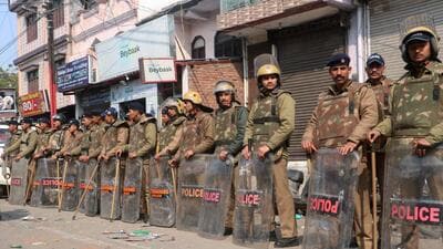 Police personnel in riot gear stand guard in Haldwani (AFP) Police personnel in riot gear stand guard in Haldwani (AFP)