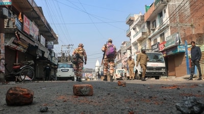 Security personnel walk past bricks and stones scattered on a road, a day after the religious clashes sparked following the destruction of a madrassa (an Islamic school) in Haldwani district of the northern state of Uttarakhand on February 9, 2024. (AFP) Security personnel walk past bricks and stones scattered on a road, a day after the religious clashes sparked following the destruction of a madrassa (an Islamic school) in Haldwani district of the northern state of Uttarakhand on February 9, 2024. (AFP)