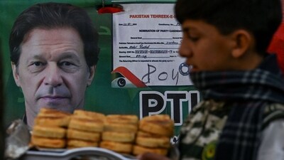A child walks past a poster showing a portrait of jailed Pakistan's former prime minister Imran Khan at a market in Lahore. (AFP) A child walks past a poster showing a portrait of jailed Pakistan's former prime minister Imran Khan at a market in Lahore. (AFP)