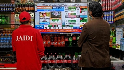 People watch latest election results live on a television at a shop, a day after Pakistan's national elections in Lahore on February 9. (AFP) People watch latest election results live on a television at a shop, a day after Pakistan's national elections in Lahore on February 9. (AFP)