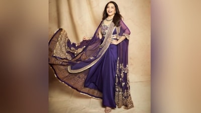 Madhuri's stunning purple ensemble consisted of a scoop neckline blouse adorned with intricate gold thread, bead and dori hand embroidery. She paired it with a matching purple silk draped skirt, a gold-bordered dupatta which she draped elegantly around her and a glamorous long-sleeved cape embellished with rich gold thread embroidery adding a royal touch to her look. (Instagram/@madhuridixitnene) Madhuri's stunning purple ensemble consisted of a scoop neckline blouse adorned with intricate gold thread, bead and dori hand embroidery. She paired it with a matching purple silk draped skirt, a gold-bordered dupatta which she draped elegantly around her and a glamorous long-sleeved cape embellished with rich gold thread embroidery adding a royal touch to her look. (Instagram/@madhuridixitnene)