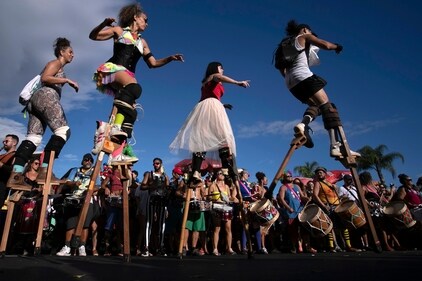 Revelers parade on wooden stilts during a pre-Carnival street party rehearsal, in Rio de Janeiro, Brazil, Jan. 21, 2024. A boom in stilt walking has altered the landscape of the world's biggest Carnival, where hundreds of stilt walkers tower over the many raucous parties that occupy and dominate public areas. (AP)