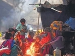 Homeless people sit around a bonfire on a cold winter morning under a National Highway flyover in Gurugram. (Parveen Kumar/HT Photo) Homeless people sit around a bonfire on a cold winter morning under a National Highway flyover in Gurugram. (Parveen Kumar/HT Photo)