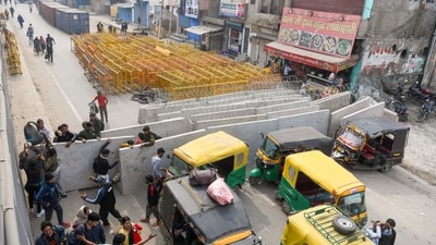 People pass the barricaded area after security tightened at the Singhu border on the eve of the farmers' call for March to Delhi, scheduled to be held on 13th February (ANI) People pass the barricaded area after security tightened at the Singhu border on the eve of the farmers' call for March to Delhi, scheduled to be held on 13th February (ANI)