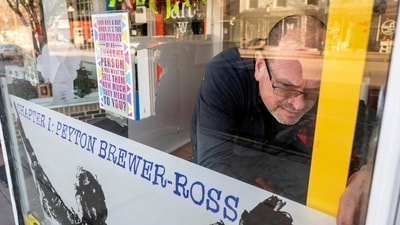 Peter Precourt levels a sign in the front window for the "There Goes My Hero: Chapter 1 Peyton Brewer-Ross" show. One of the 18 people killed in the deadliest mass shooting in Maine history is being remembered in art, including some of his own. An art exhibit this weekend paid tribute to Peyton Brewer-Ross, a Navy shipbuilder and father. (Joe Phelan/The Kennebec Journal via AP) Peter Precourt levels a sign in the front window for the "There Goes My Hero: Chapter 1 Peyton Brewer-Ross" show. One of the 18 people killed in the deadliest mass shooting in Maine history is being remembered in art, including some of his own. An art exhibit this weekend paid tribute to Peyton Brewer-Ross, a Navy shipbuilder and father. (Joe Phelan/The Kennebec Journal via AP)