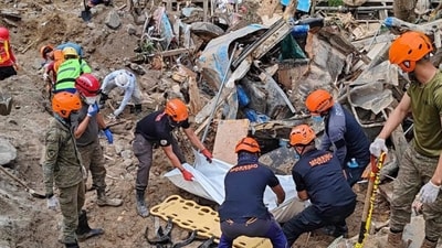 Rescuers recover bodies at the landslide-hit village of Maco in Davao de Oro province, southern Philippines. (AP)