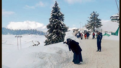 Tourists at snow-clad Gulmarg in Baramulla on Monday. (ANI)