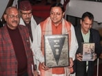 Dehradun: Uttarakhand Chief Minister Pushkar Singh Dhami with others holds a copy of the Constitution of India, at Vidhan Sabha Bhawan, in Dehradun, Tuesday, Feb. 6, 2024. The Uniform Civil Code bill, which proposes uniform marriage, divorce, land, property and inheritance laws for all citizens irrespective of their religion in Uttarakhand, was tabled in the state assembly on Tuesday. (PTI Photo) (PTI02_06_2024_000053A)