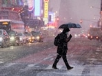 A morning commuter walks through wind and snow during a Nor'easter winter storm in the Times Square area in New York City, U.S., February 13, 2024. REUTERS/Brendan McDermid