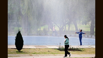 A visitor enjoying the mist from a fountain at Rose Garden, Sector 16, in Chandigarh on a sunny Tuesday afternoon. (Ravi Kumar/HT)