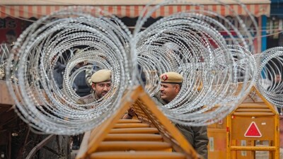 Farmers protest: Police personnel guard near concertina wires installed near Tikri border in view of farmers' 'Delhi Chalo' march, near New Delhi, Tuesday. (PTI) Farmers protest: Police personnel guard near concertina wires installed near Tikri border in view of farmers' 'Delhi Chalo' march, near New Delhi, Tuesday. (PTI)