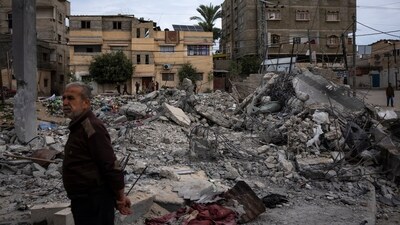 Neighbors inspect the rubble of the Hasouna family house, which was struck by an Israeli airstrike during an operation to rescue two hostages in Rafah, southern Gaza Strip, Tuesday, Feb. 13, 2024. Ibrahim Hasouna, who was away at the time of the airstrike, says his entire family was killed, including his parents, two brothers, his sister-in-law and three nieces and nephews. AP/PTI(AP02_14_2024_000001B) (AP) Neighbors inspect the rubble of the Hasouna family house, which was struck by an Israeli airstrike during an operation to rescue two hostages in Rafah, southern Gaza Strip, Tuesday, Feb. 13, 2024. Ibrahim Hasouna, who was away at the time of the airstrike, says his entire family was killed, including his parents, two brothers, his sister-in-law and three nieces and nephews. AP/PTI(AP02_14_2024_000001B) (AP)