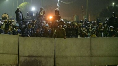 Police and Rapid Action Force (RAF) personnel block a highway to prevent farmers from marching towards India's capital. (AFP) Police and Rapid Action Force (RAF) personnel block a highway to prevent farmers from marching towards India's capital. (AFP)