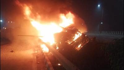 The 16-wheel truck, which was carrying stone chips, veered off course, rammed into the divider, overturned, fell into a five-foot-wide drain between both carriageways, and burst into flames. (HT) The 16-wheel truck, which was carrying stone chips, veered off course, rammed into the divider, overturned, fell into a five-foot-wide drain between both carriageways, and burst into flames. (HT)