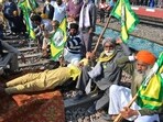 Protesting farmers demanding guaranteed crop prices for their produce sit on train tracks at a railway station in Rajpura, Punjab.