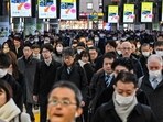 Commuters walk through Shinagawa Station during the morning rush hour in Tokyo.