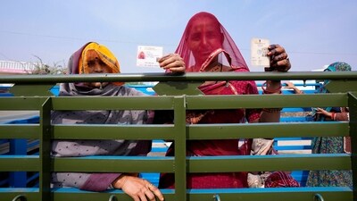 Women display their voter's identity card sitting in the back of a truck in Chachiyawas, near Ajmer, India, Saturday, Nov. 25, 2023. (AP) Women display their voter's identity card sitting in the back of a truck in Chachiyawas, near Ajmer, India, Saturday, Nov. 25, 2023. (AP)
