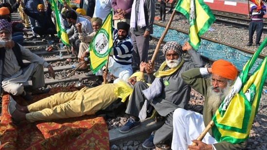 Protesting farmers demanding guaranteed crop prices for their produce sit on train tracks at a railway station in Rajpura, Punjab. (AP)