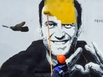 Alexei Navalny dies: A worker paints over graffiti of jailed Kremlin critic Alexei Navalny in Saint Petersburg.