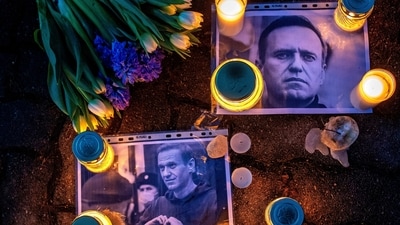 Photos of jailed Russian opposition leader Alexei Navalny with flowers and candles are laid on a ground in front of the Russian embassy in Vilnius, Lithuania, on Feb. 16. (AP)