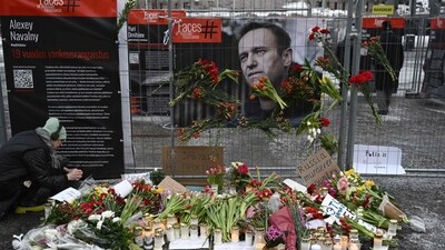 Candles and flowers are brought to a makeshift memorial. (AFP) Candles and flowers are brought to a makeshift memorial. (AFP)